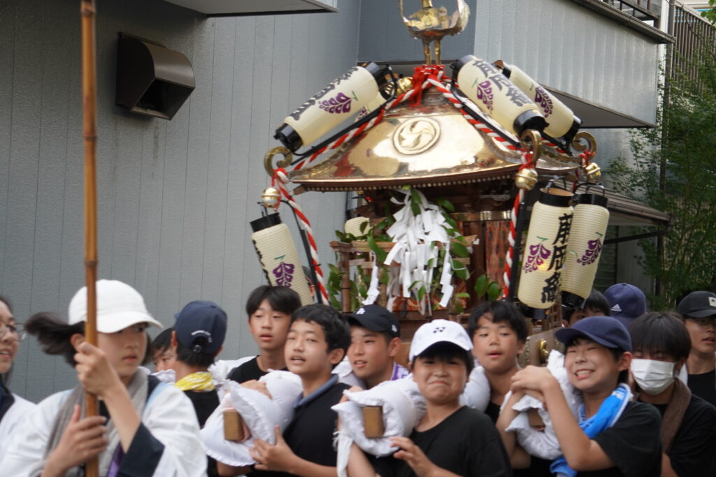 神輿を担ぎ出発する中学生