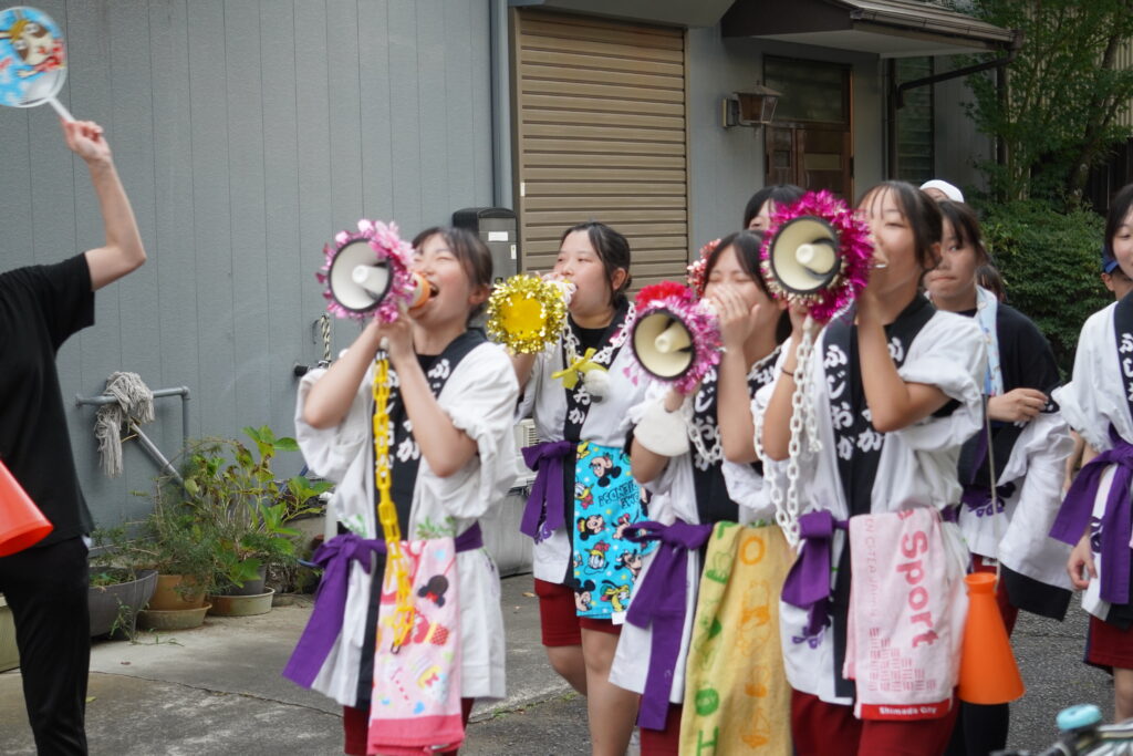 メガホンで声をだす中学生