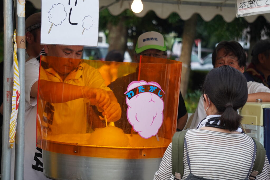 綿菓子を作る人とそれを見る子供