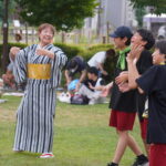 盆踊りを楽しそうにする中学生と老人