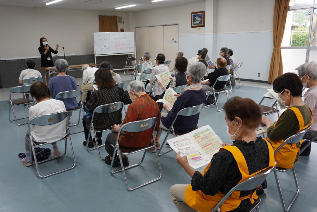 乗り合いタクシーの説明と、それを聞く会員さん