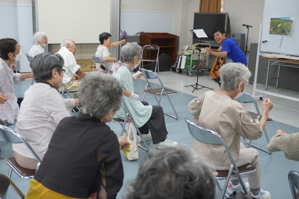 塚本さんと一緒に手を振っている会員さん