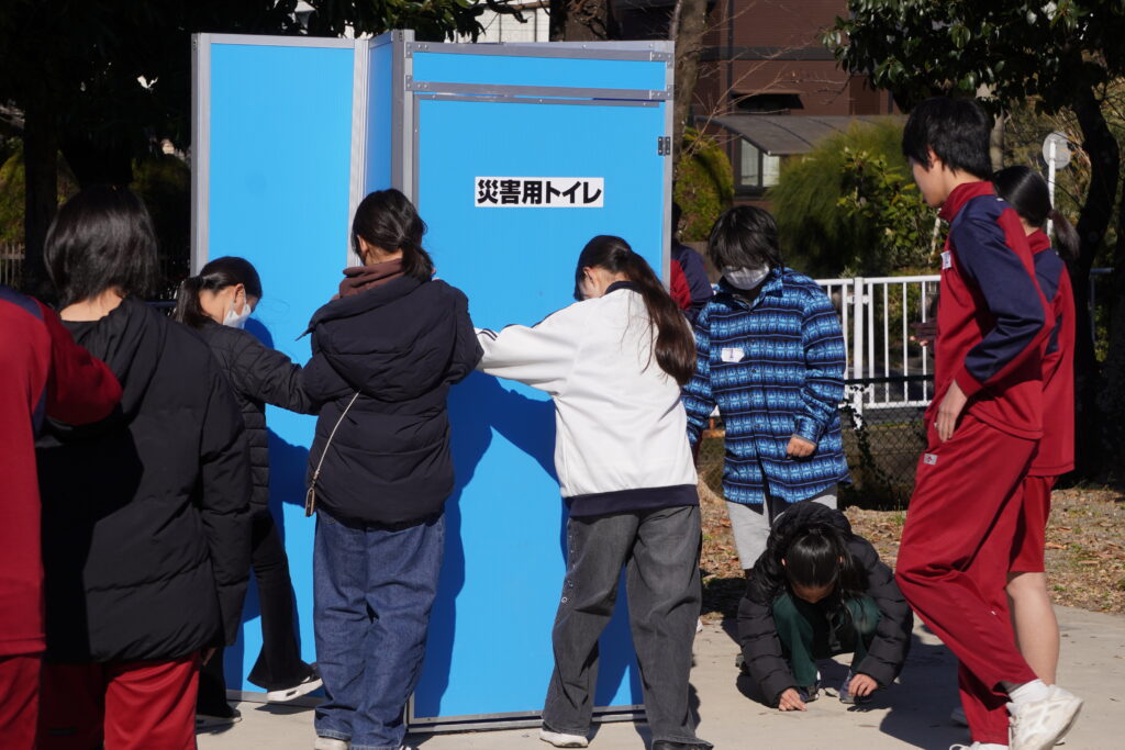 マンホールトイレを組み立てる子供達