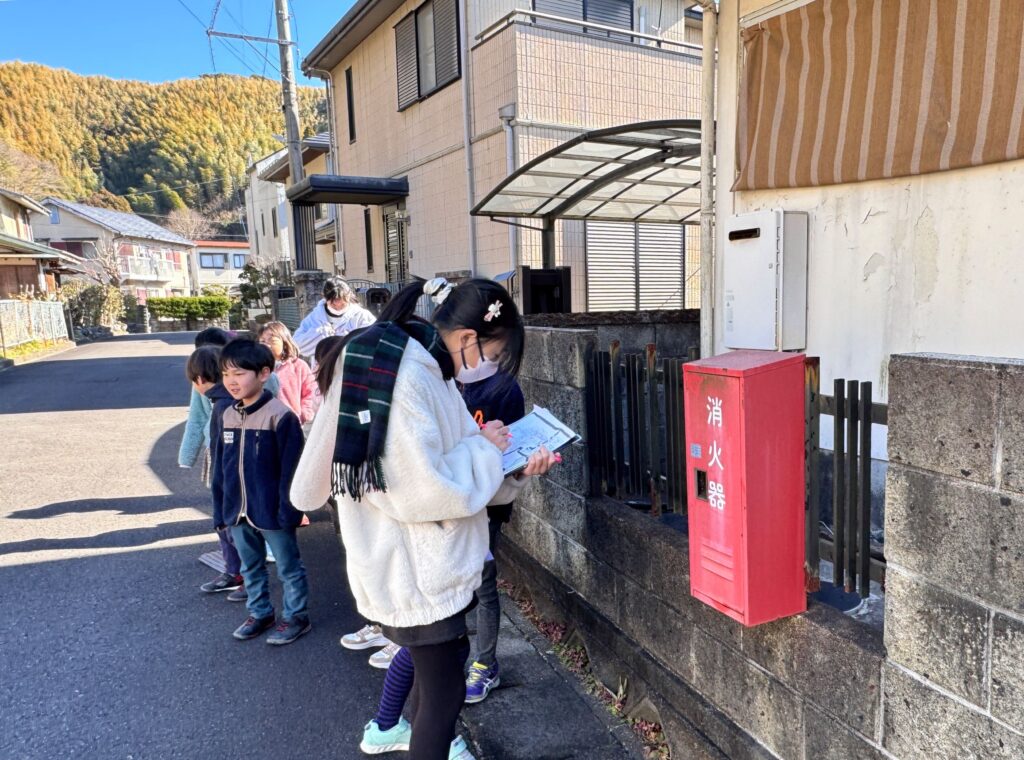 消火器を前に地図に書き込む生徒