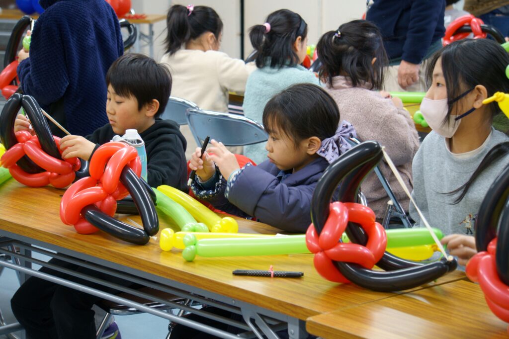 完成したバルーンの弓と矢を見たり、触る子どもたち