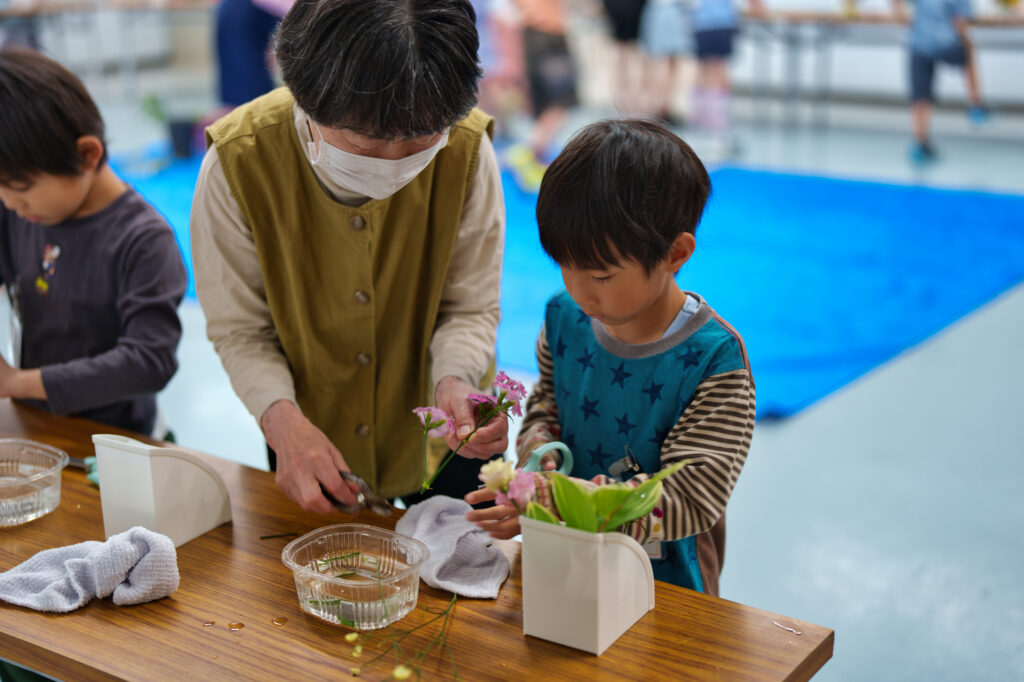 サポーターに教えてもらいながら、花を活ける子どもたち