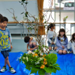 活けた雲龍椿を見る子どもたち