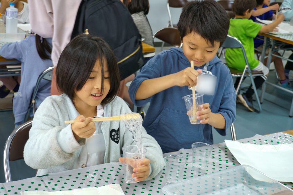 割りばしでかき混ぜる子どもたち