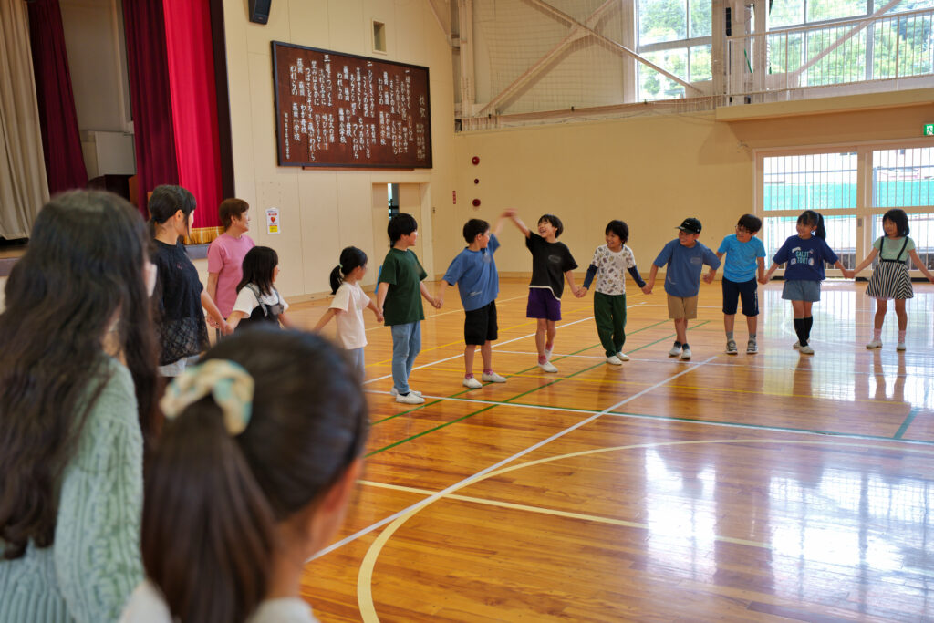 名前を言いながらつないだ手を回し、波を作る子どもたち