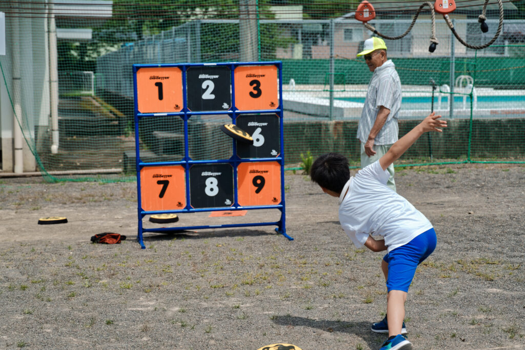 ディスゲッターで、得点板にフリスビーを投げる子ども