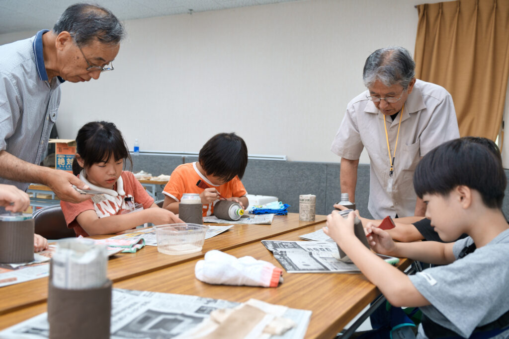 底を張り付けた子どもたちと、見守る先生たち