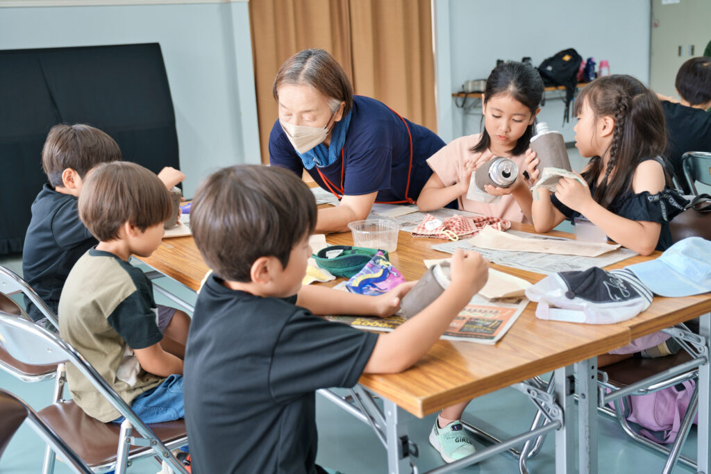 底を張り付けた子どもたちと、見守るサポータ