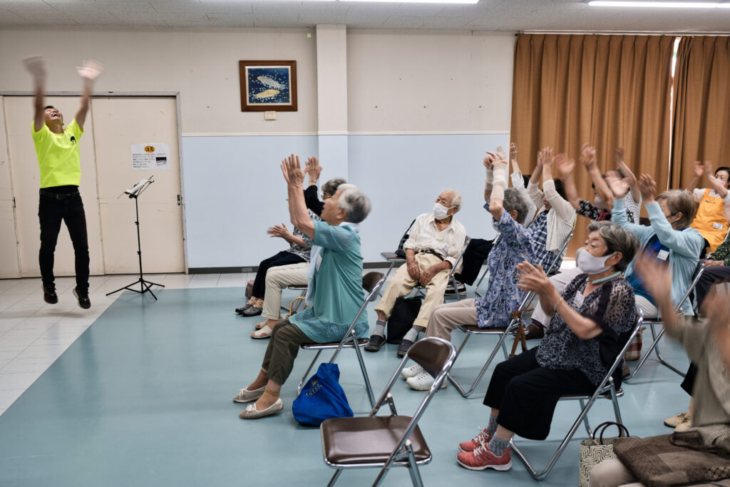 ジャンプして手を叩く講師と、頭上で手を叩く会員たち