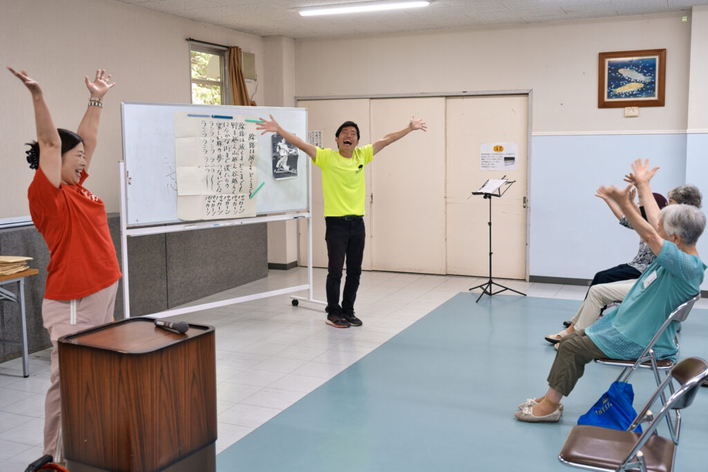 頭上で手を叩く講師と会員たち