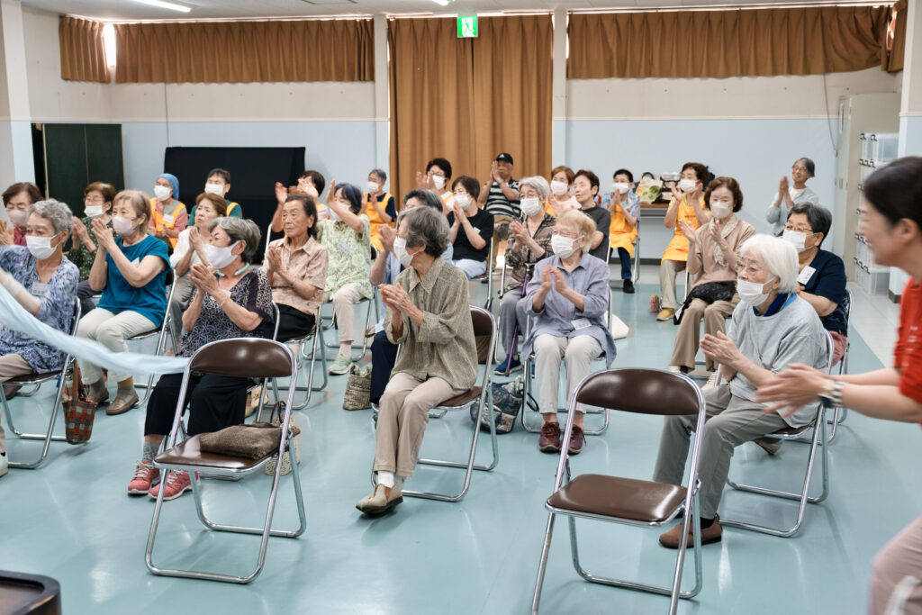 手を叩き、タオルを振る会員たち