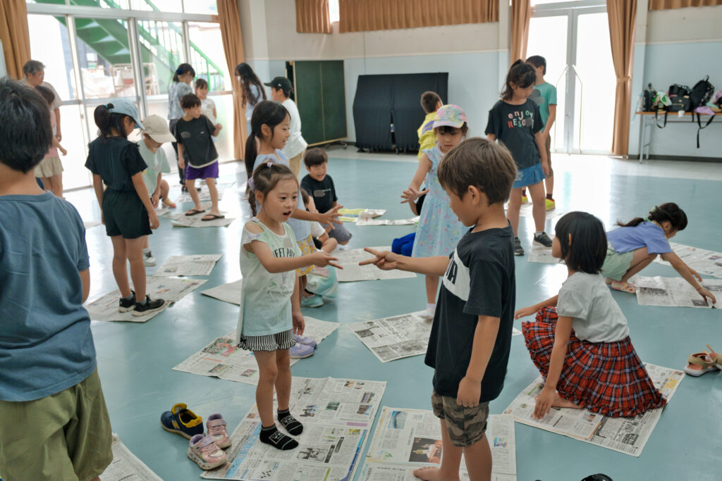 新聞紙の上でじゃんけんをする子どもたち