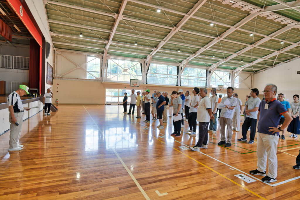 選手たちが整列し、自治会長の挨拶を聞く、開会式の様子