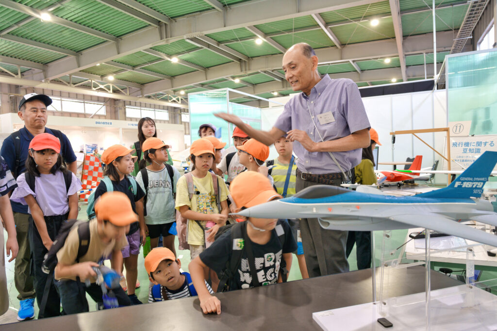 模型の前で航空資料館の方から解説を聞く子どもたち