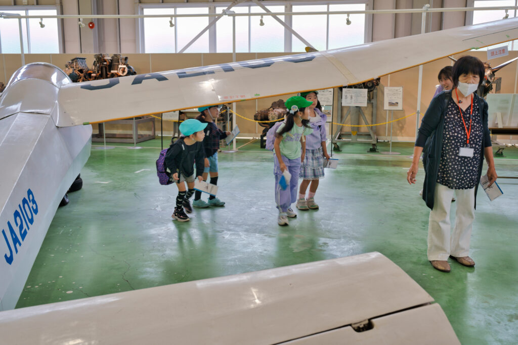 飛行機の下をくぐる子どもたち
