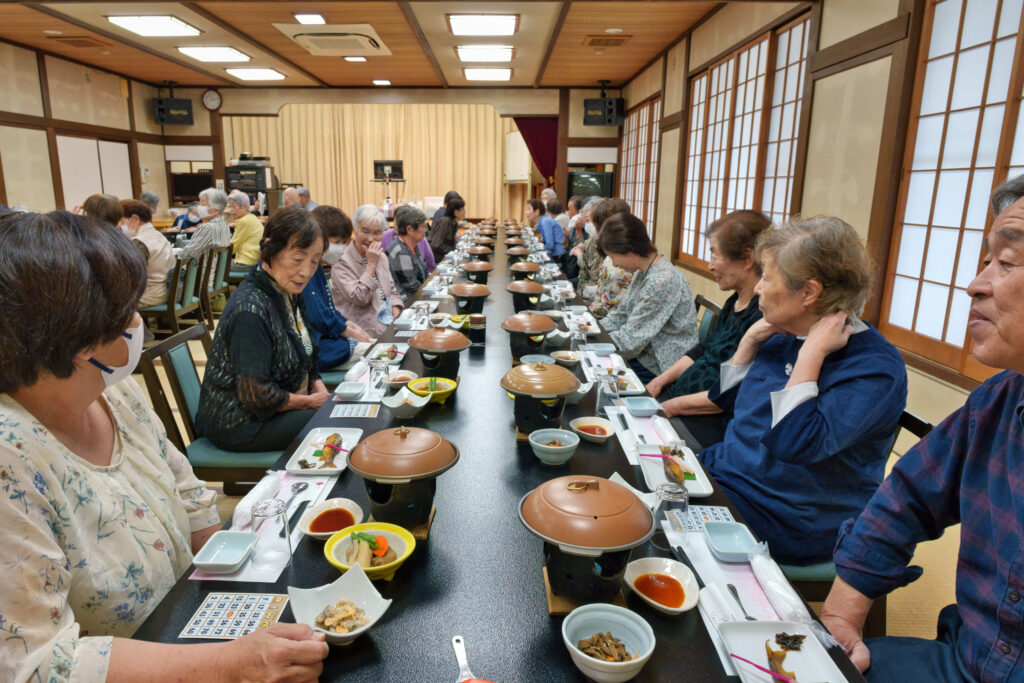 並んでいる料理を楽しそうにみる会員たち