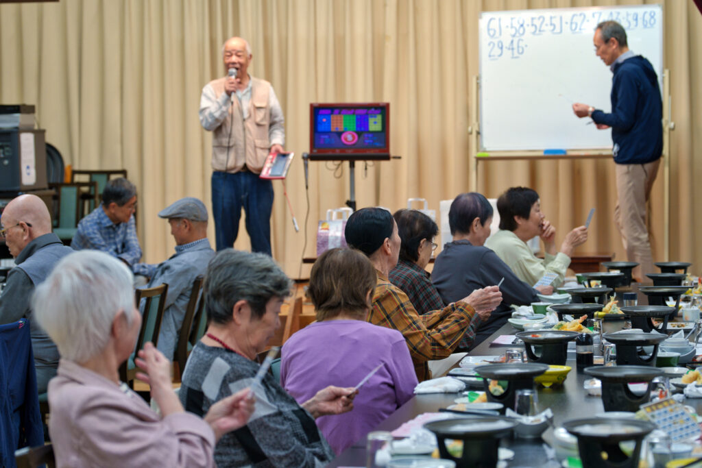 ビンゴの司会をするボランティアたち
