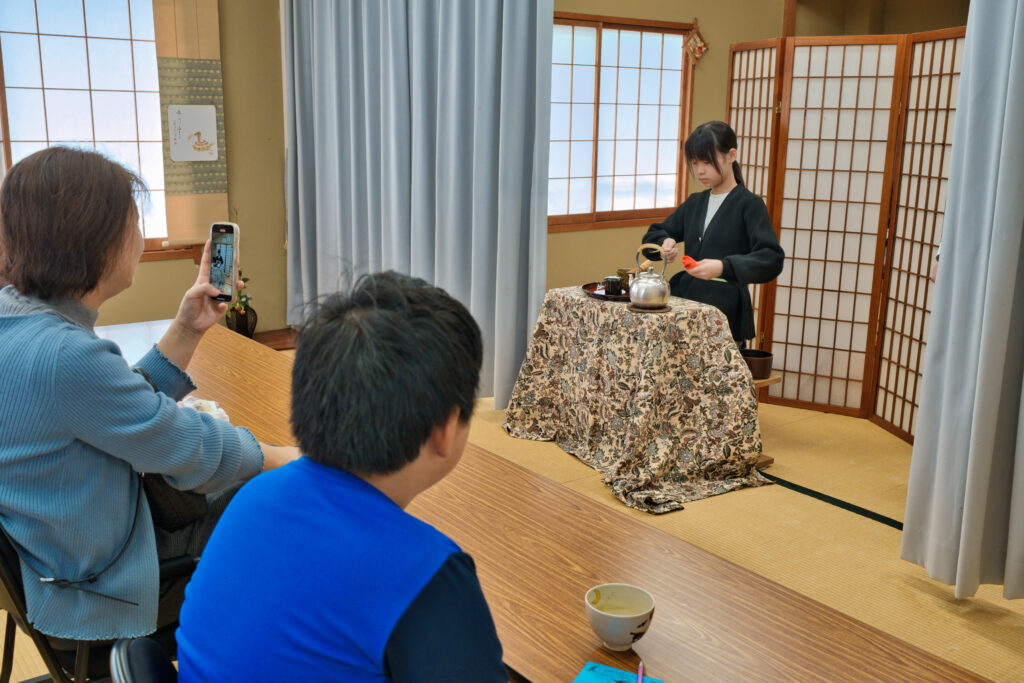 お点前をする小学生と、席に座る住民の皆さん