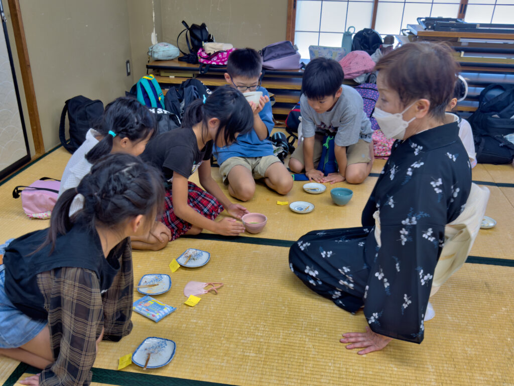 先生から抹茶をいただく子どもたち