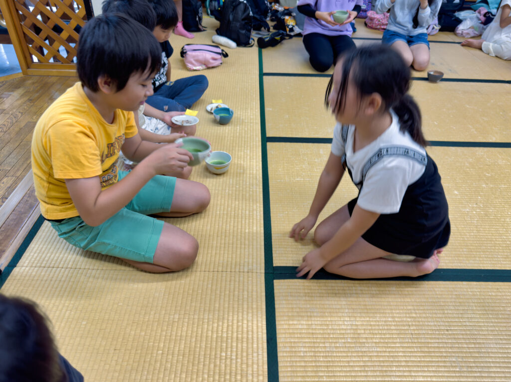抹茶を相手に渡す子ども