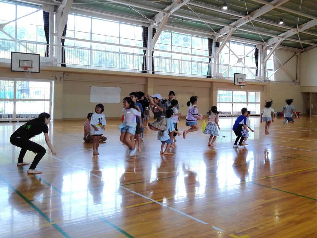 縄を使わずに大縄跳びを行う子どもたち