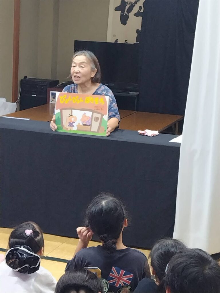 蛙の紙芝居を読む「ふしぎなたまご」
の方と、聞く子どもたち