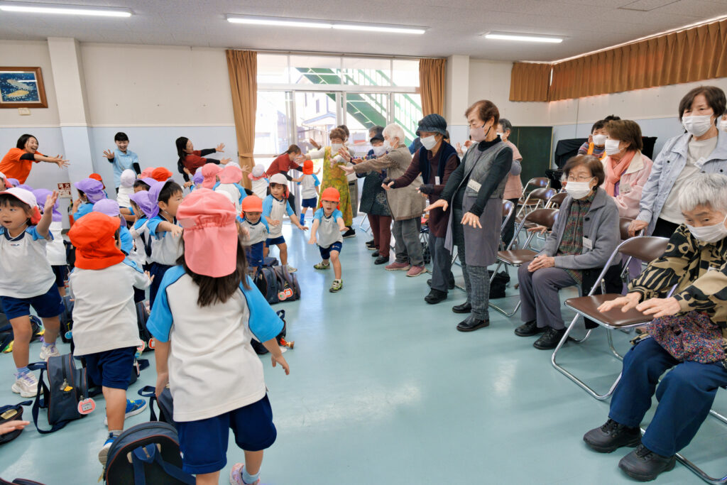 幼稚園児と一緒に「昆虫太極拳」をする会員たち