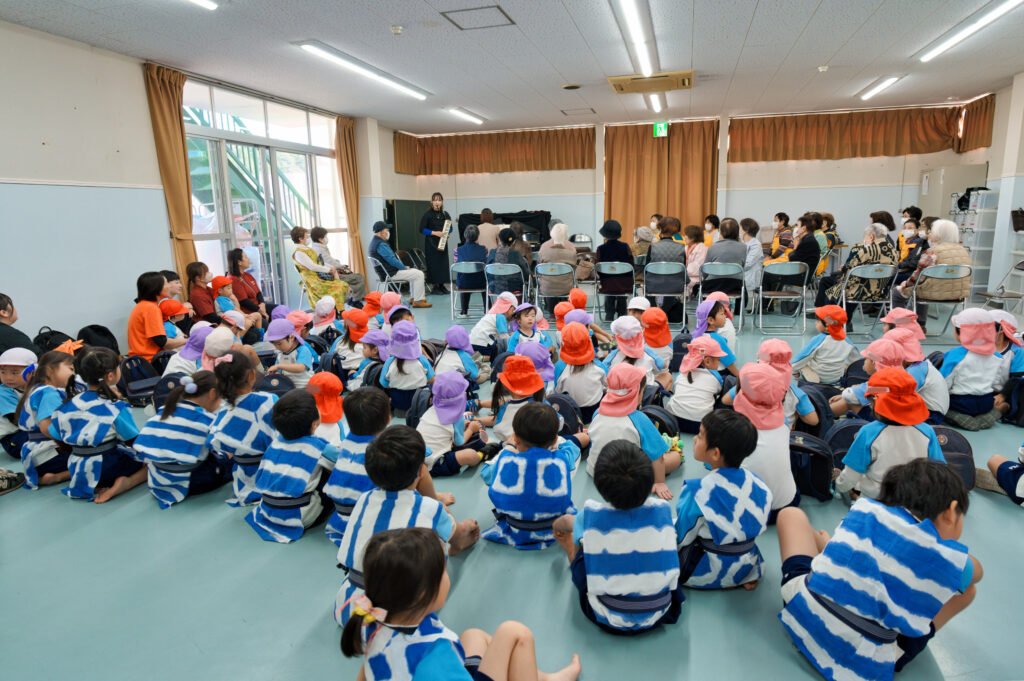歌を歌う幼稚園児と会員たち