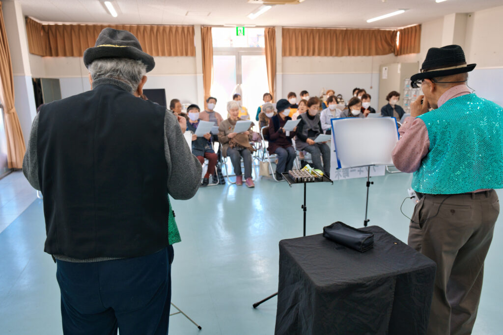 G＆Gの二人がハーモニカとコードハーモニカの演奏を行い、会員たちが歌を歌う