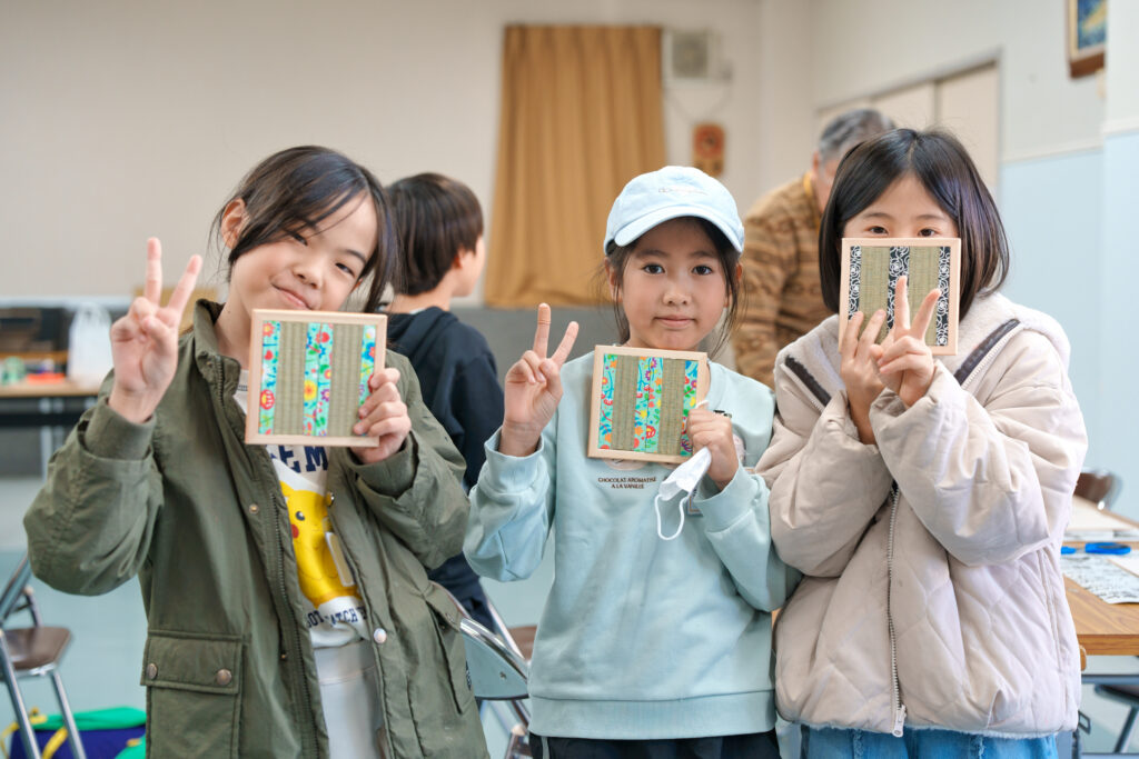 ミニ床置きを手に記念撮影する子どもたち