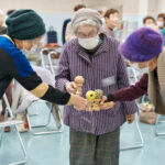 皿に球を乗せたけん玉を手に持ち、歩いて交流をする会員たち