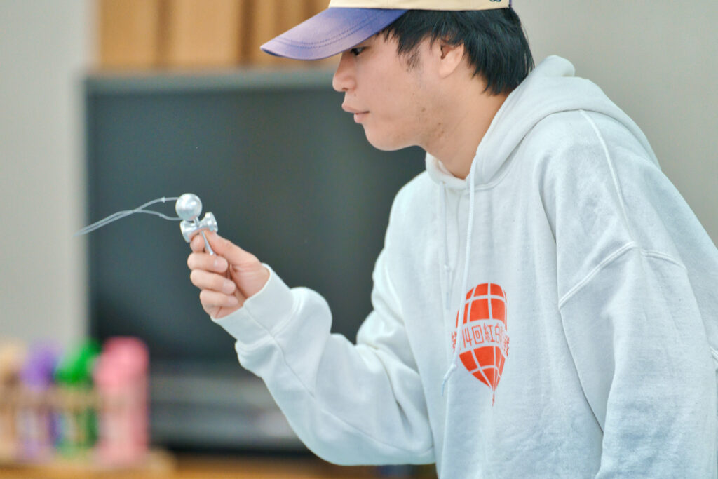 手のひらより小さなけん玉で、球の穴にけんを入れる「とめけん」を行うぎんちゃん