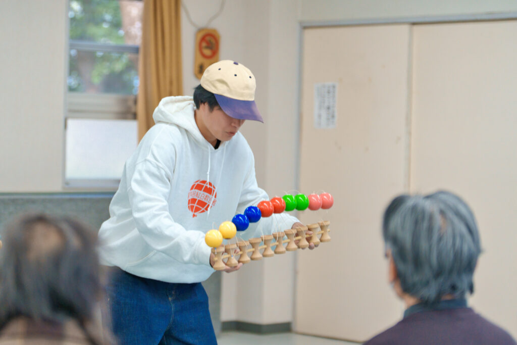 10個のけん玉がつながったけん玉で、球を皿に乗せているぎんちゃん