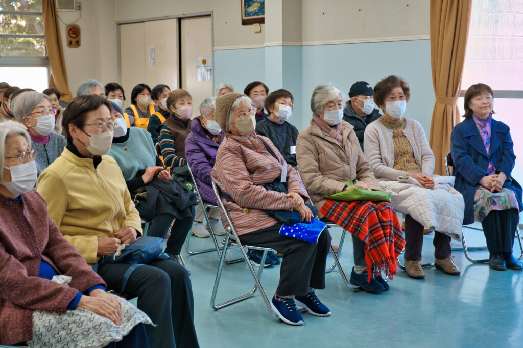 八卷夫妻の挨拶を聞く観客たち