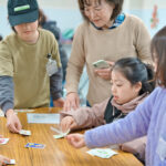 手札のカードで得点カードを入手するゲームを真剣に遊ぶ子どもたち