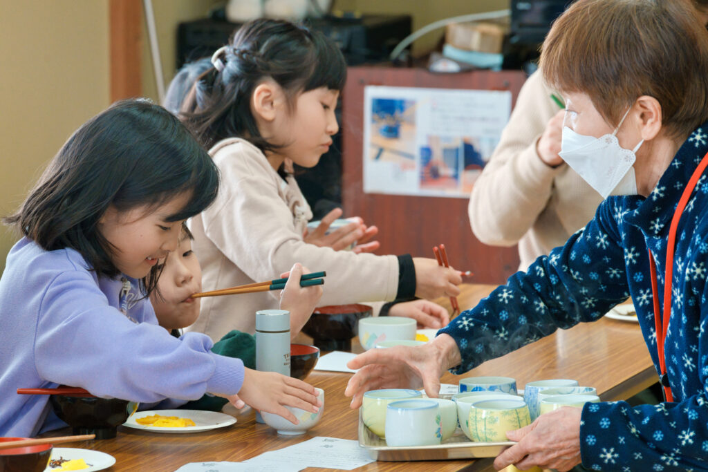 先生からお茶をもらう子どもたち