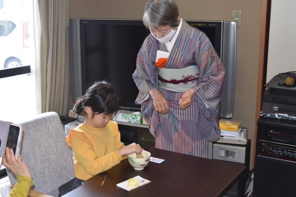 お点前体験をする小学生と、見守る先生