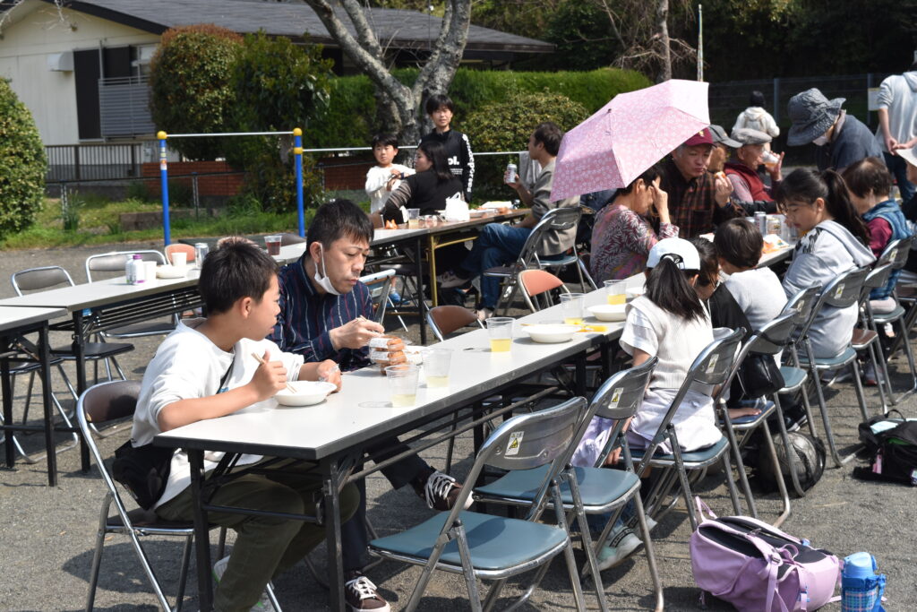 屋外のテーブルで食事をする人々
