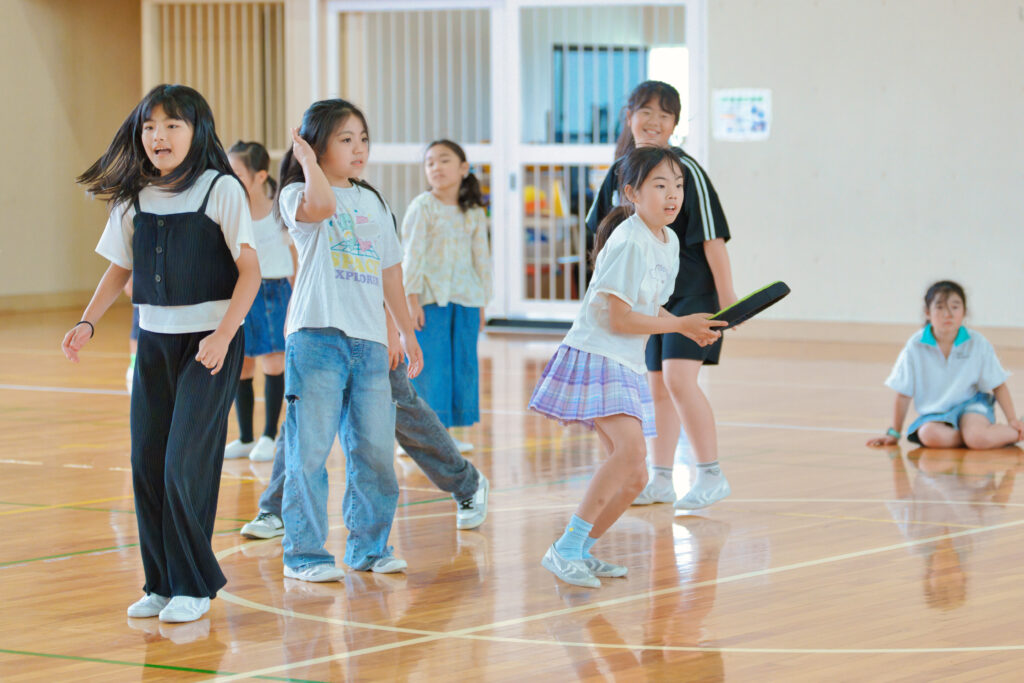 フリスビーを投げようとする子どもと、同じチームも子どもたち