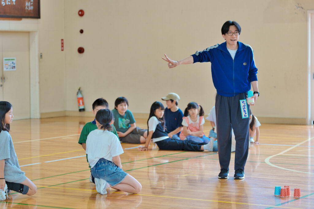 ゲームのルールを説明するいっぺいちゃんと、それを聞く子どもたち