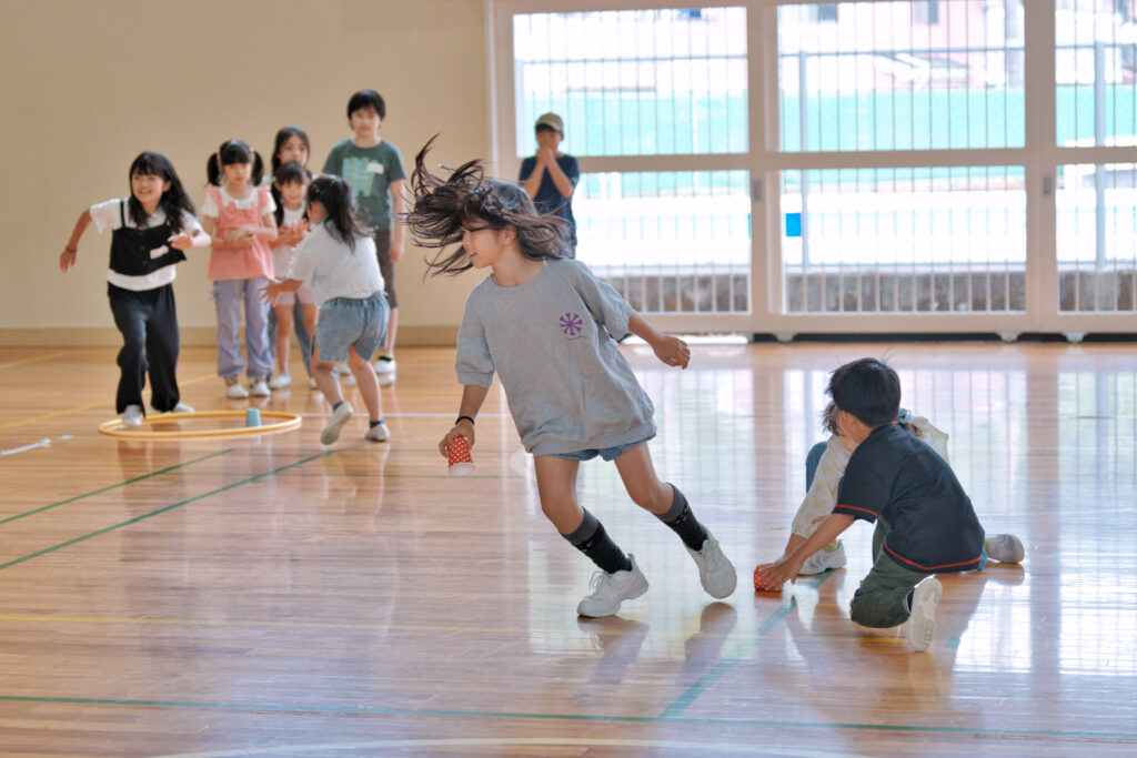 中央の紙コップを取って走る子どもたち