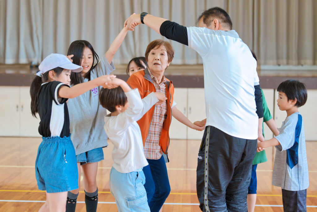 手を繋いだまま円に戻ろうとする子どもたちｔ先生たち
