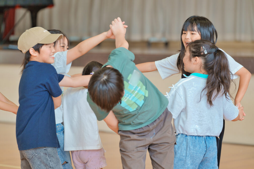 手を繋いだまま円に戻ろうとする子どもたち