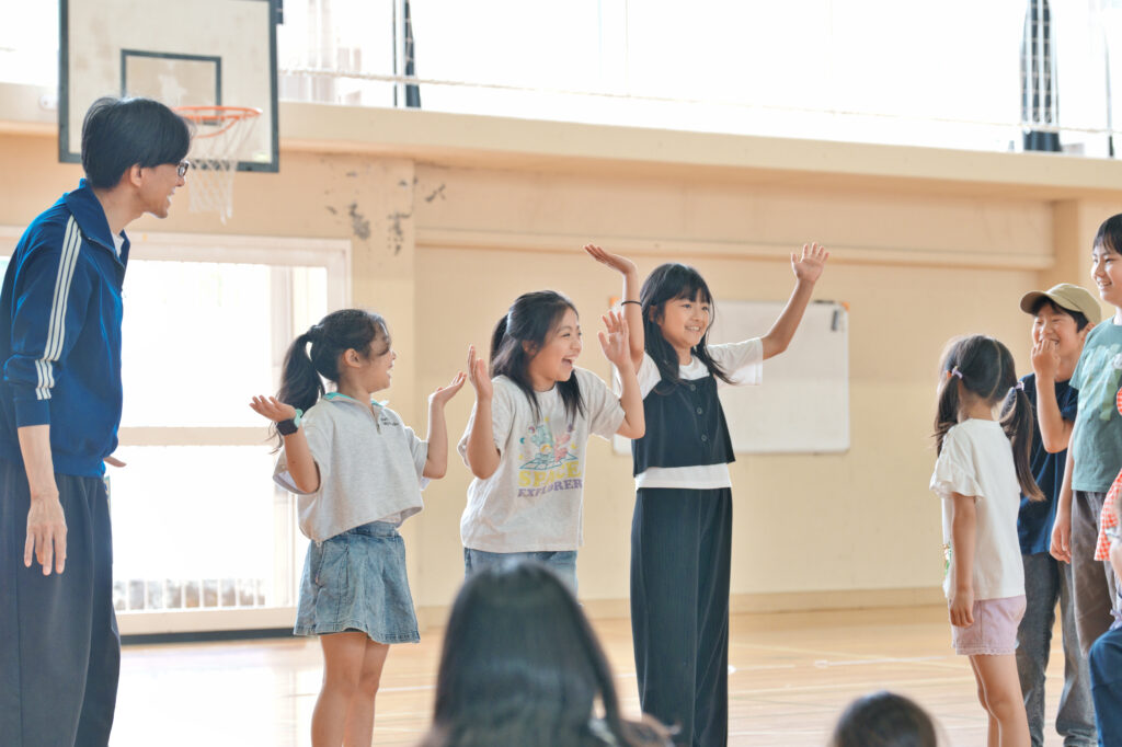腕を使い花を表現する子どもたち