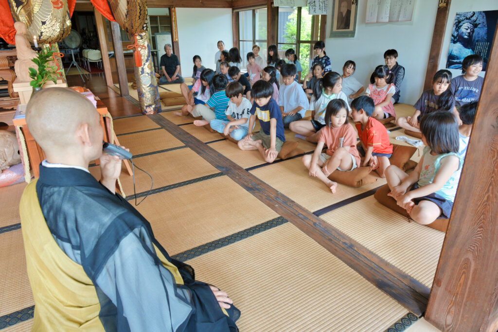 お坊さんの前で座禅を組もうとする子どもたち