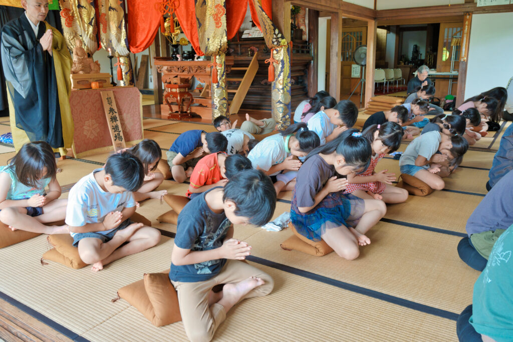 座禅のまま手を合わせ、祈っている子どもたち